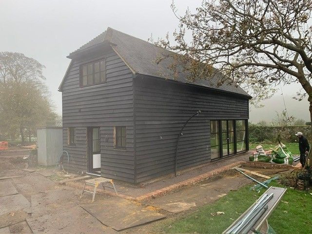 Black timber-clad barn conversion with Heritage Doors