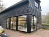 Black timber-clad barn conversion with Heritage Doors